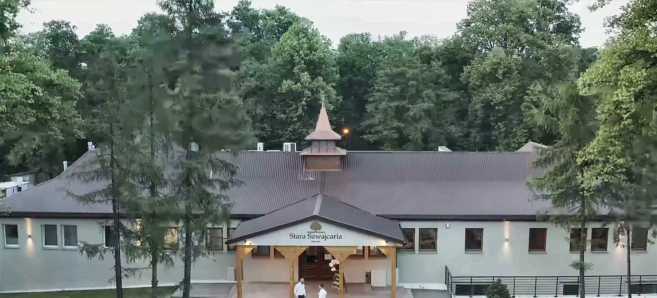 The entrance to Stara Szwajcaria: a timber canopy carrying the venue's name board