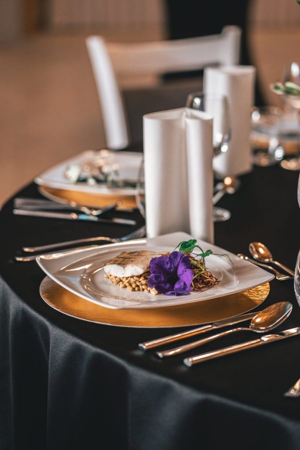A plated dish with an edible flower, in the restaurant's warm light