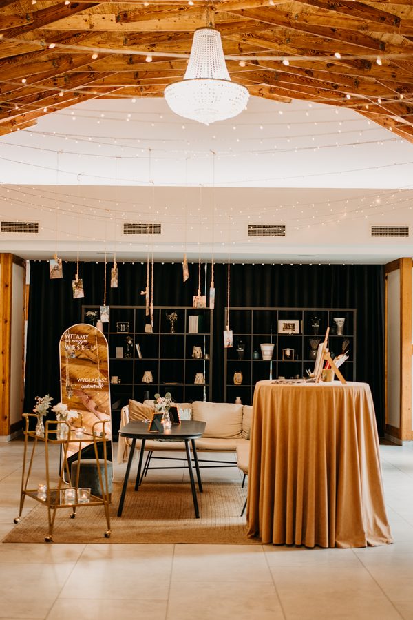 The chill-out zone in Diamentowa: a crystal chandelier under the timber ceiling, a sofa and a low table