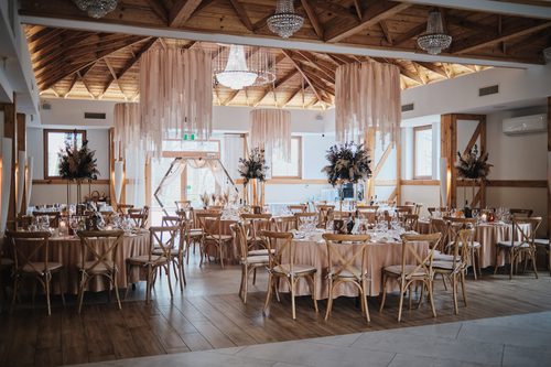 The Kryształowa hall with blush drapes hung from the trusses