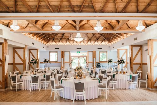 The Kryształowa hall with round tables and crystal chandeliers