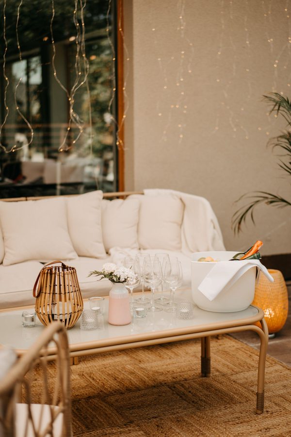 A sofa and low table on the terrace, glasses and wine in an ice bucket