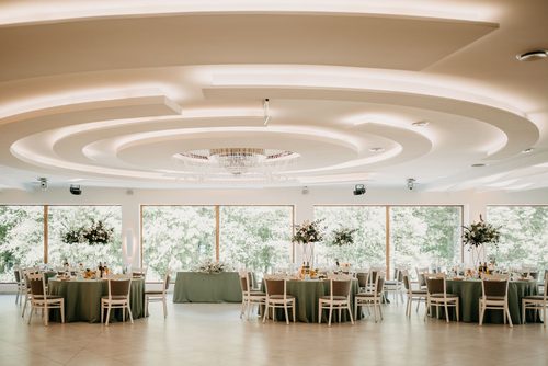 The Tarasowa hall with tables in sage green, under the lit domed ceiling