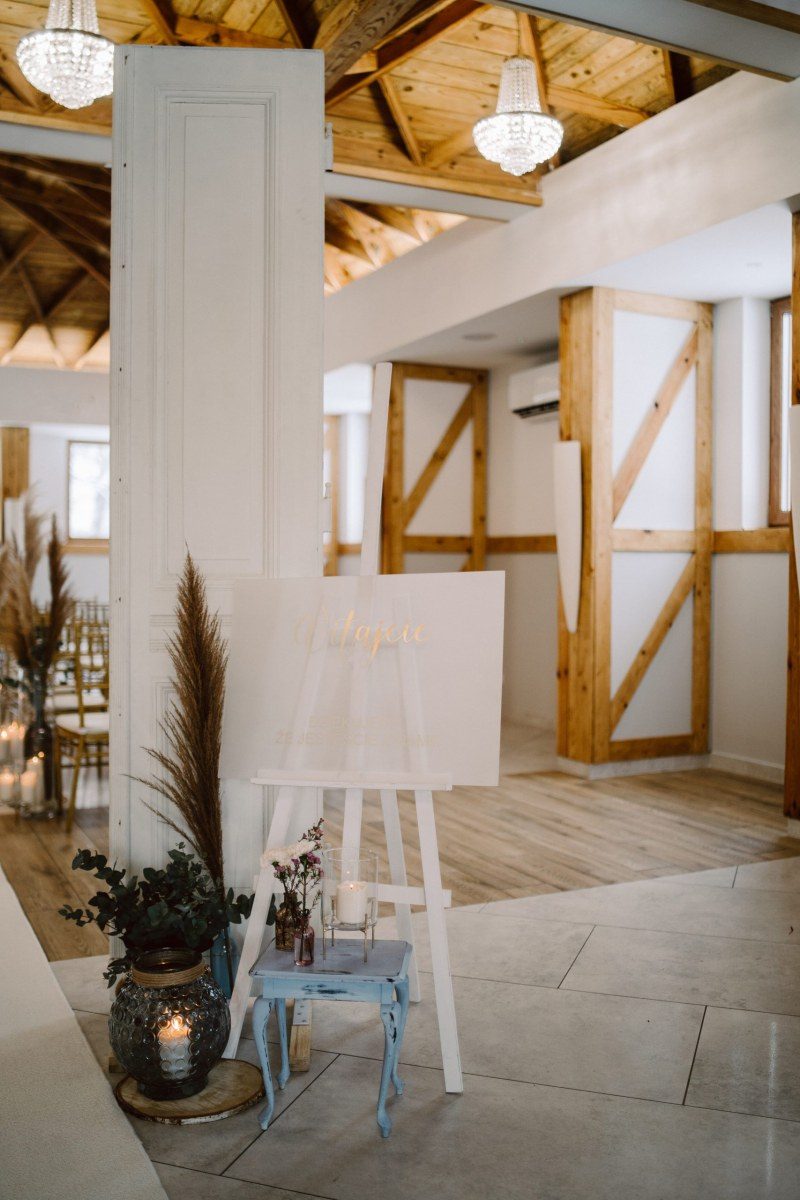 The entrance to the hall: an easel with a welcome board, candles and roof trusses